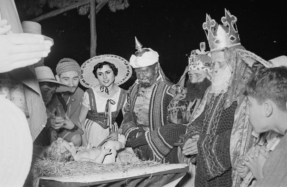 Los Reyes Magos en los años 50 se acercan al Niño Jesús.