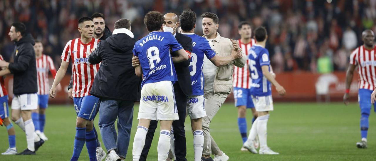 Una de las tanganas que se produjeron al final del Sporting-Oviedo en El Molinón. | Juan Plaza / Marcos León