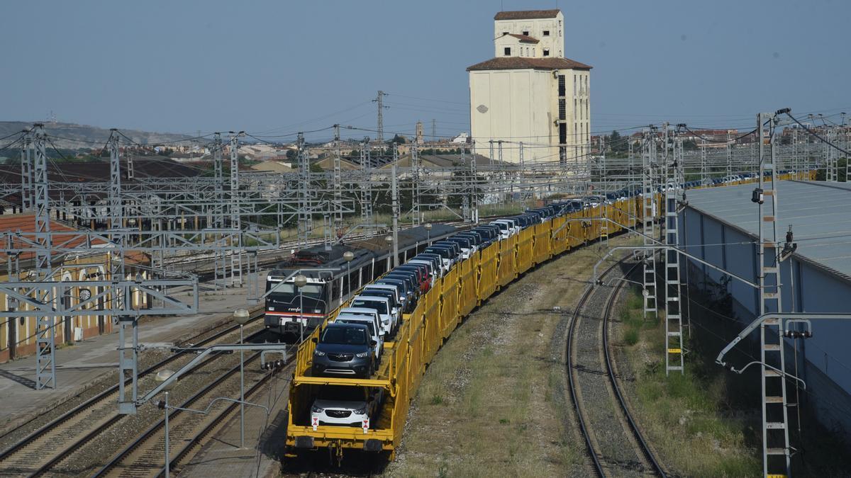 Imagen de archivo. Un tres, a su paso por la estación de Casetas, transporta coches desde la factoría de Stellantis.