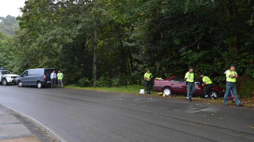 Agentes y trabajadores de la funeraria junto al vehículo.