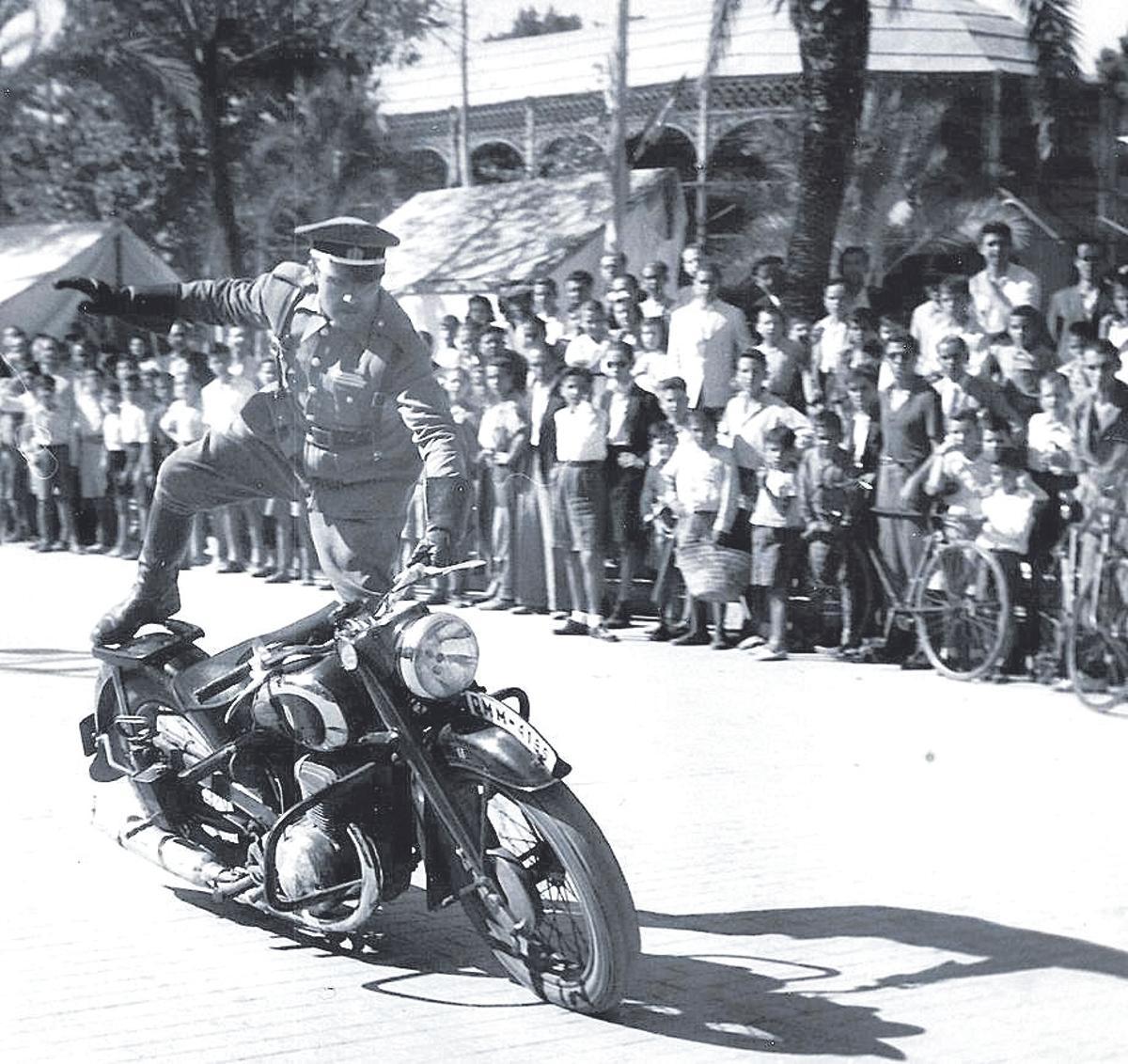 -Un agente de la Policía Armada realiza un ejercicio de destreza sobre la motocicleta durante una demostración en el paseo de la Victoria, en 1944.