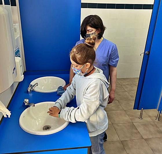 Sara Carbajal se lava las manos ante la mirada de María Antonia Silgado.