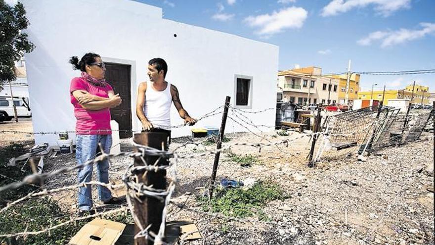 Marta Perdomo y Juan Hormiga, junto a la valla militar colocada en el entorno de las casas de El Matorral.