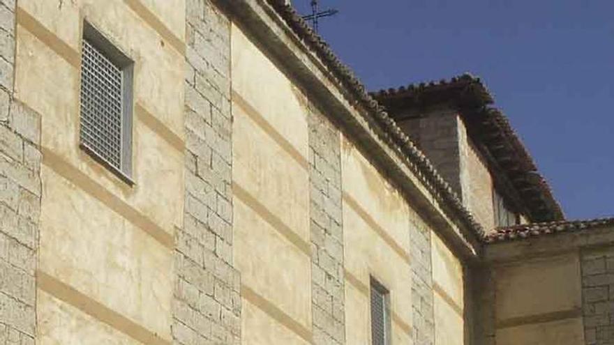 Dos vecinos conversan junto a la fachada principal de la iglesia. Foto