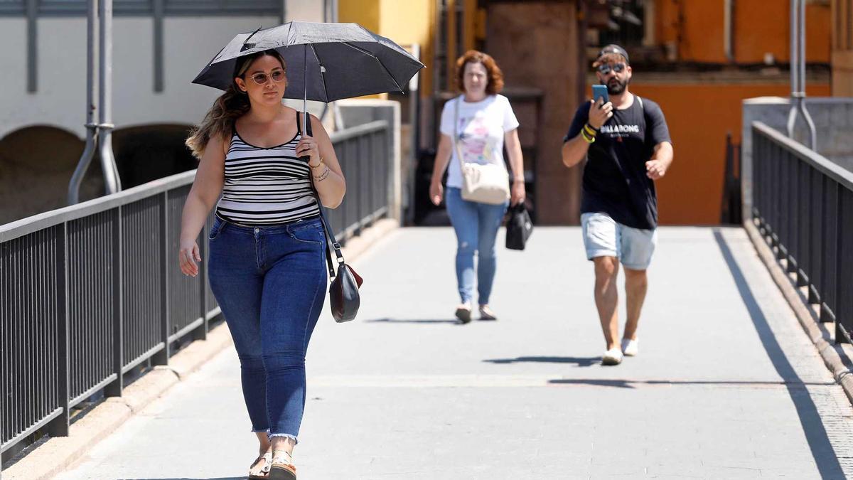 Vianants passejant sota la calor, a Girona