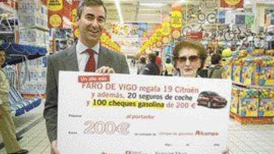 Pilar Díaz recibe el cheque entregado por Miguel González-Puelles. / C. Pereira