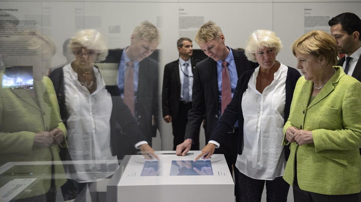 BERLÍN (ALEMANIA) 08/11/2017.- La Canciller alemana Angela Merkel (r), la Comisaria de Cultura y Medios Monika Grütters (c), y el director del Memorial Hohenschönhausen de Berlín, Hubertus Knabe (l), visitan la antigua prisión de la policía secreta de la era comunista de Alemania Oriental, conocida como Stasi, en Berlín (Alemania), hoy, 11 de agosto de 2017. La prisión se convertirá en un museo de la memoria como parte de un proyecto de casi 9 millones de euros en memoria de Hohenschönhausen en Berlín.