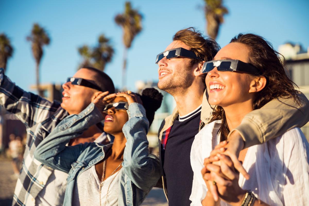 Grupo de amigos viendo un eclipse con gafas homologadas.
