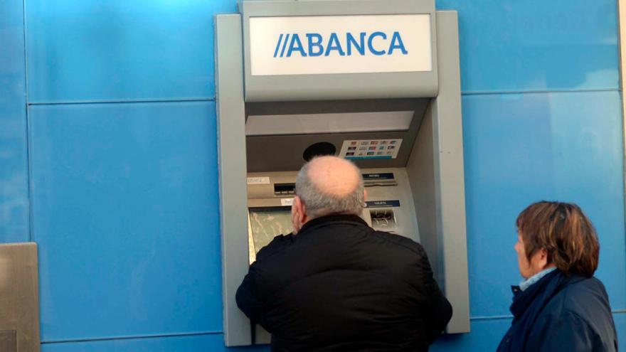 Usuarios tratan de sacar dinero en un cajero de Abanca // Noe Parga