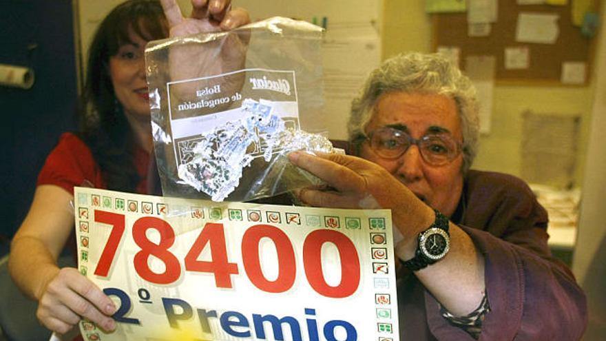 Una mujer de más de 70 años muestra hoy en el Centro Comercial &quot;Carrefour-Los Ángeles&quot;, en Madrid, un décimo del 78.400, número agraciado con el segundo premio de la Lotería de Navidad, hecho añicos, después de que, según ella, se le olvidara en el bolsillo de una bata que metió en la lavadora.