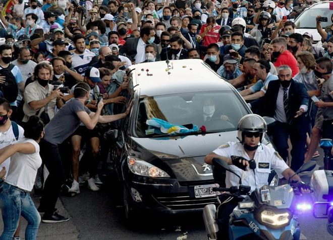 Decenas de hinchas caminan detrás del cortejo fúnebre que traslada los restos de Diego Armando Maradona desde la Plaza de Mayo hasta el  cementerio privado Jardín Bella Vista donde ya estaban enterrados los padres del futbolista.