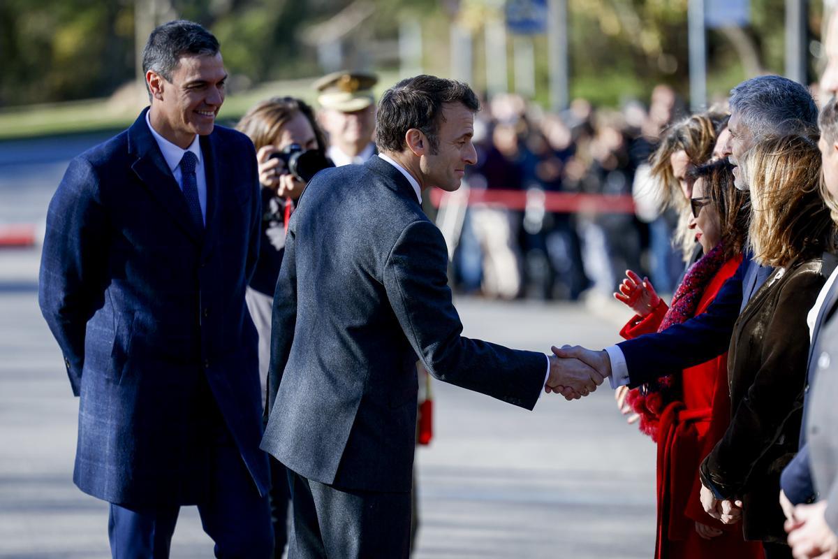 El presidente francés, Emmanuel Macron, saluda al ministro español del Interior, Fernando Grande-Marlaska, en presencia del presidente del Gobierno, Pedro Sánchez, a su llegada a la Cumbre.