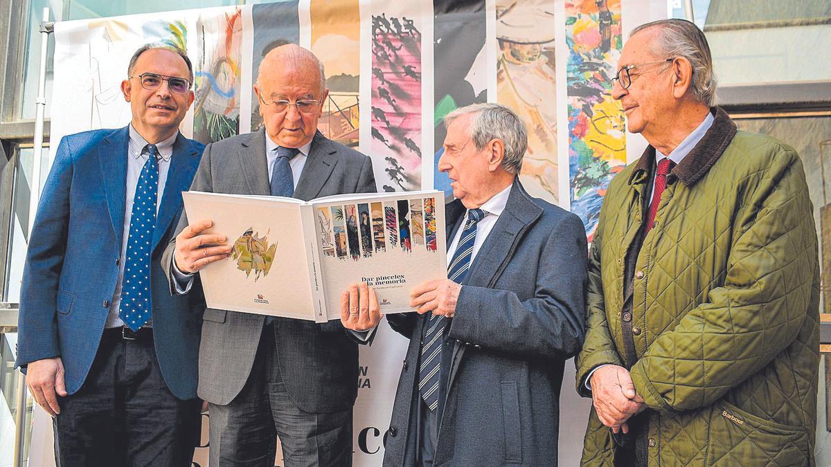 Carlos Egea (segundo por la  izquierda) observa el catálogo durante la presentación.