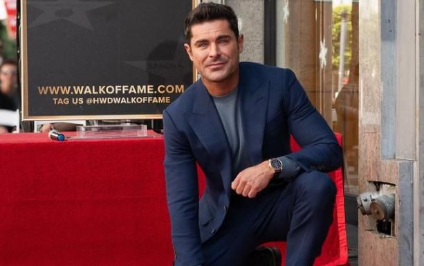 Zac Efron posando junto a su estrella del paseo de la fama