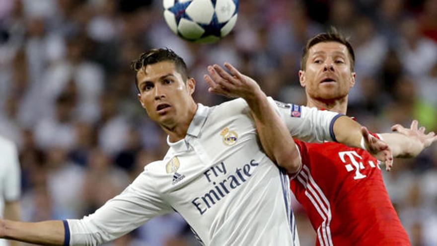 Cristiano Ronaldo pugna por un balón con Xabi Alonso.