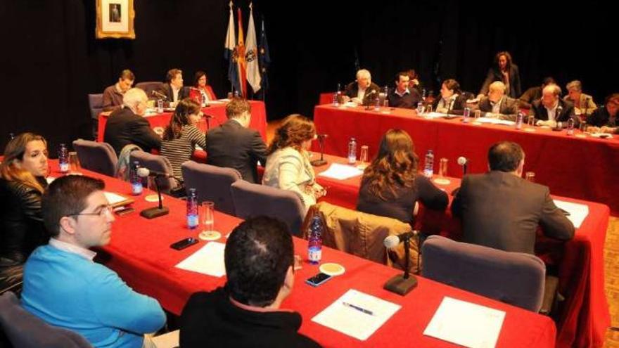 El grupo municipal del PP, de espaldas, frente a los del BNG y del PSOE, en el pleno de ayer.  // G. Santos