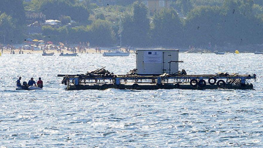 La batea depuradora o de &quot;reinstalación&quot; colocada a finales de 2011 frente al puerto de Aldán.  // G.Núñez