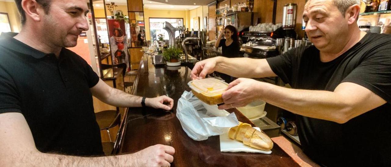 Uno de los camareros sirve un plato del día en un «tupper».