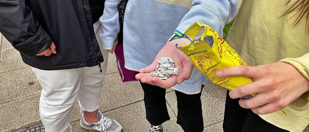 Tres adolescentes con un puñado de pipas en una calle de Avilés.