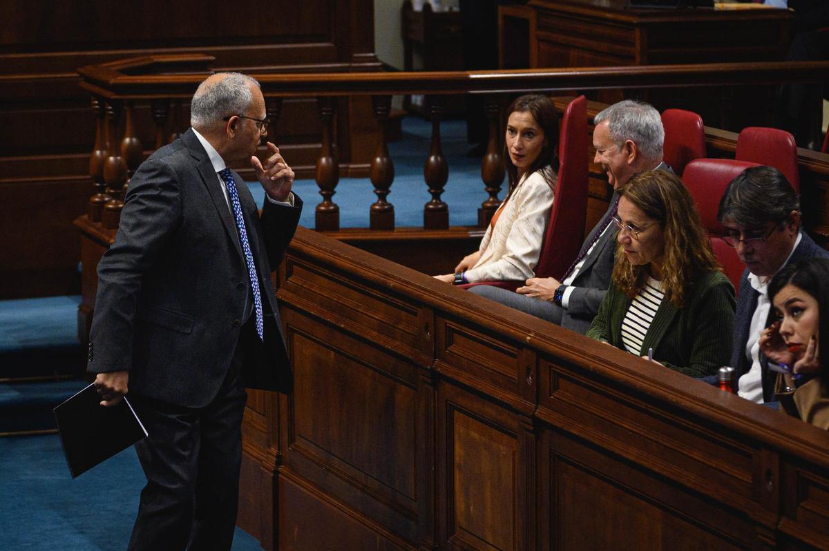 Casimiro Curbelo (i) conversa con el portavoz socialista, Sebastián Franquis, después de su intervención en el pleno del Parlamento.