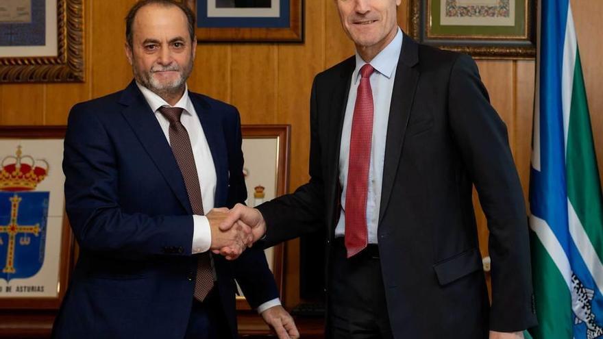 Tomás Manuel Fernández, a la izquierda, y Manuel Menéndez se saludan tras la firma del convenio de colaboración.