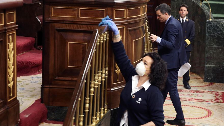 Una trabajadora desinfecta la tribuna del Congreso en el primer Pleno del confinamiento.