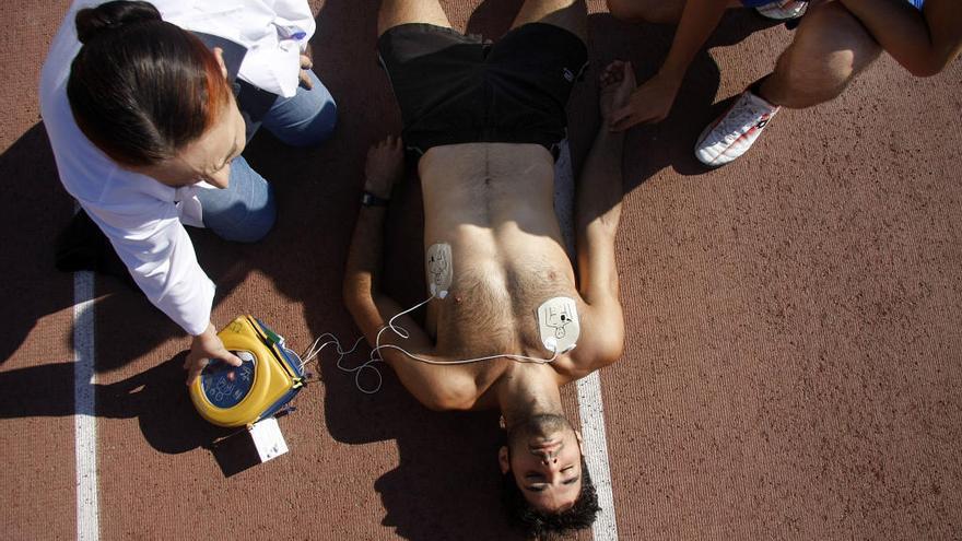 Simulacro del uso de un desfibrilador en una pista deportiva.