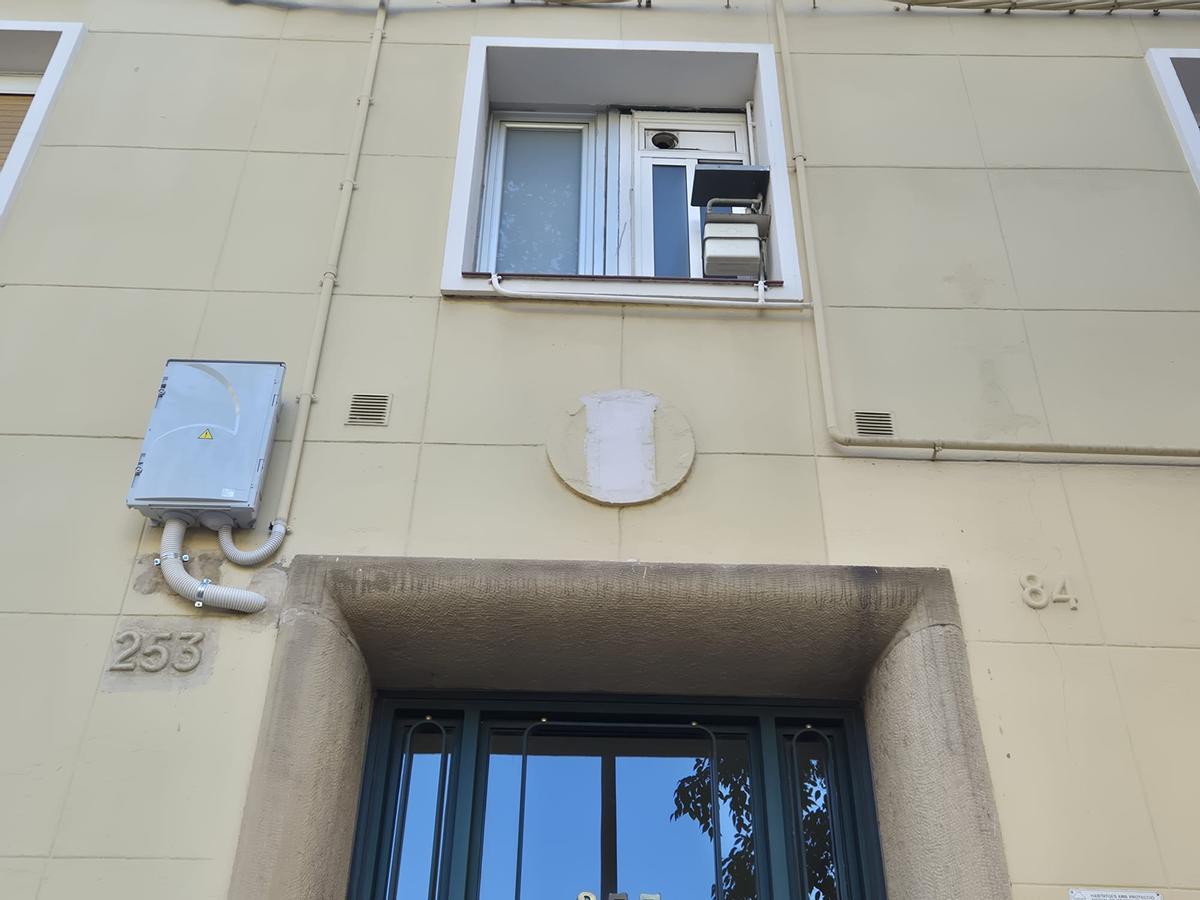 Un medallón de la Obra Sindical del Hogar, cubierto con un brochazo en el distrito de Sant Martí, en Barcelona.