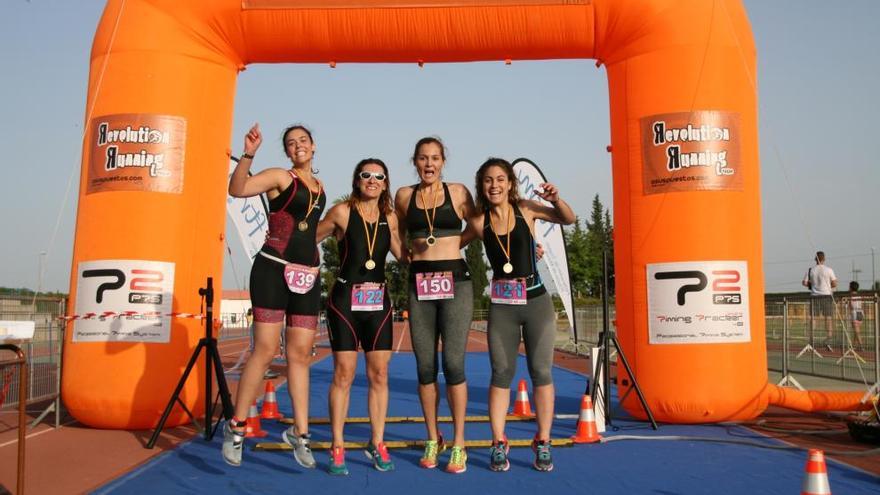 Un grupo de participantes en el Triatlón Popular de la Mujer, en la meta celebrando que han concluido la prueba.