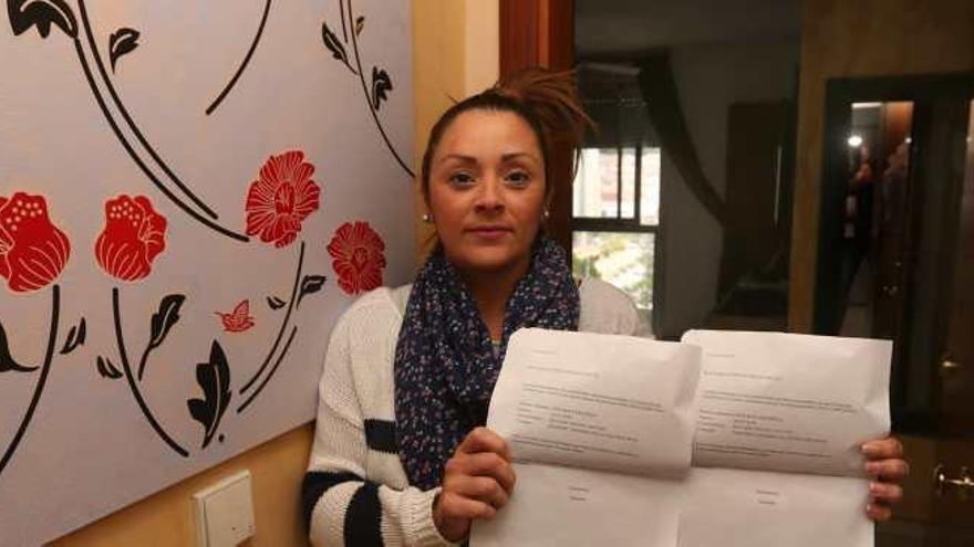 Vanessa, en su casa, muestra el escrito que certifica el pago del recibo por parte de Cruz Roja.