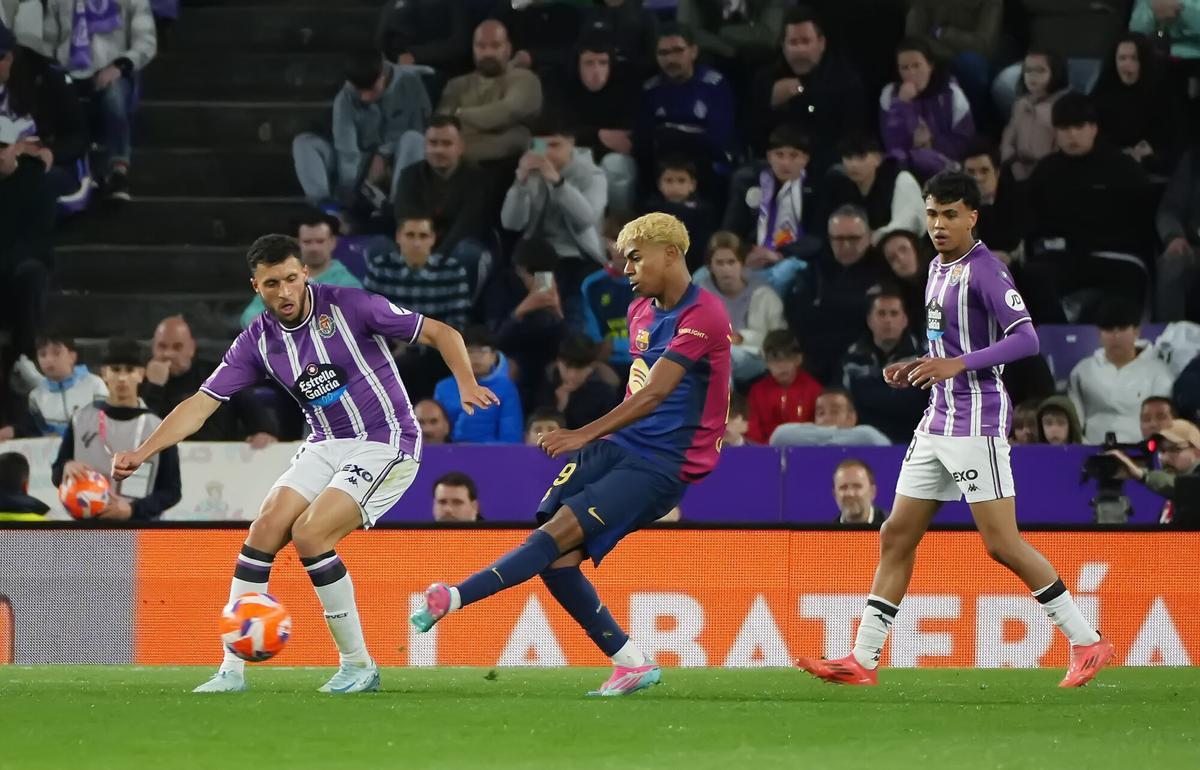 VALLADOLID, 03/05/2025.- El delantero del Barcelona Lamine Yamal (c) juega un balón entre dos jugadores del Valladolid, durante el partido de LaLiga de fútbol que Real Valladolid y FC Barcelona disputan este sábado en el estadio José Zorrilla. EFE/R. García
