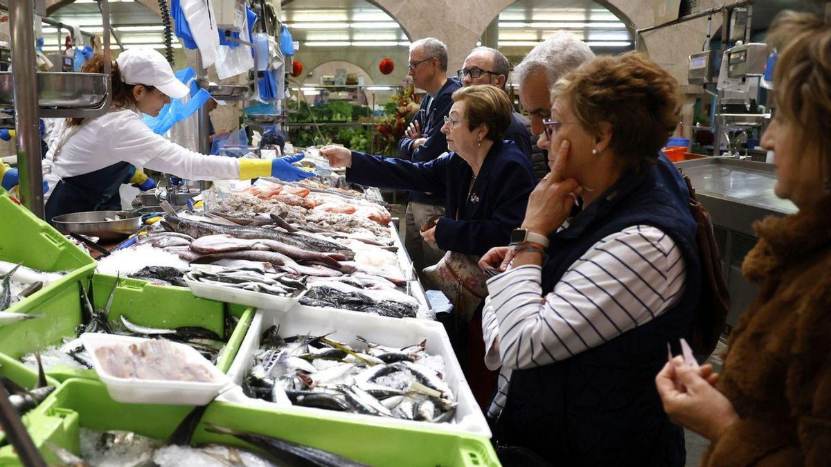 Varios clientes esperan su turno en una pescadería del Mercado de Pontevedra.