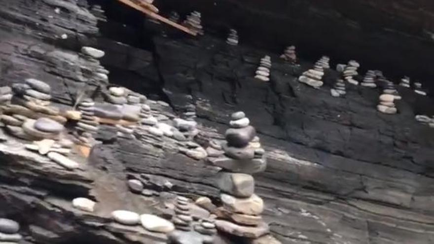 Los montones de piedras apilados en los pliegues de uno de los acantilados de la playa de As Catedrais.