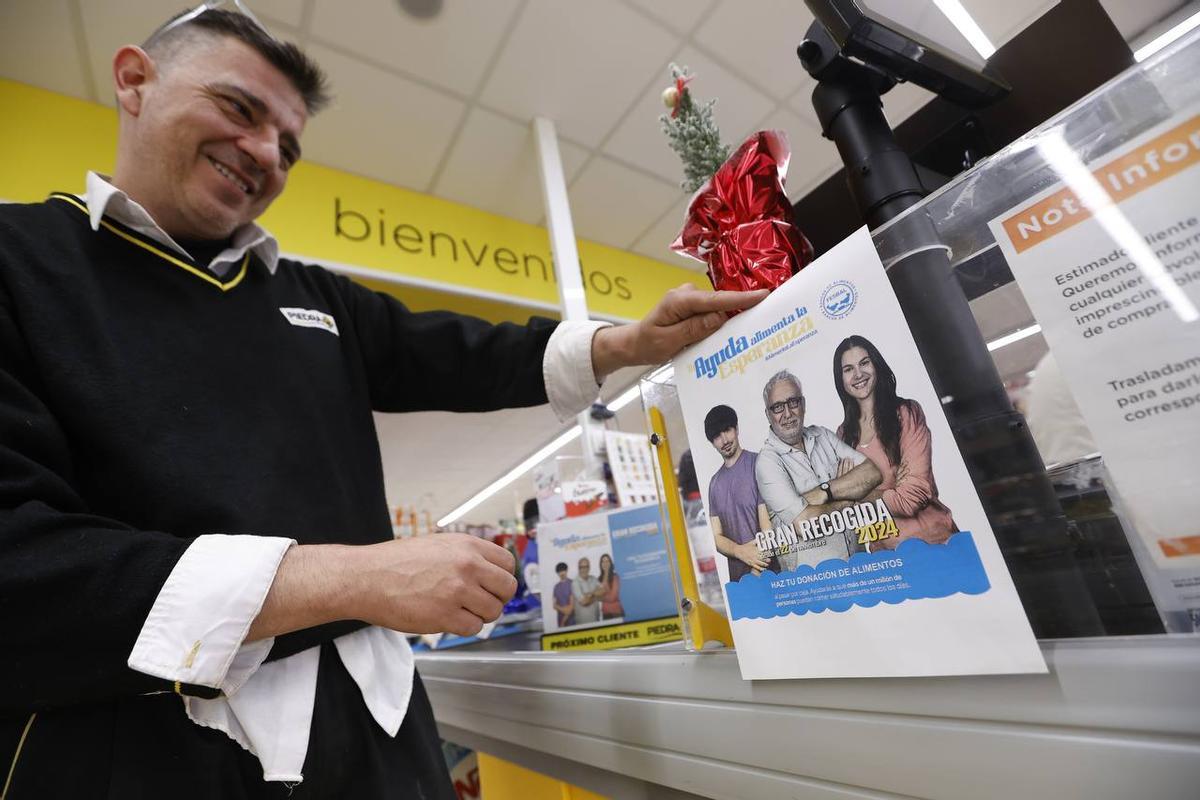 Un empleado de Piedra coloca el cartel de la Gran Recogida.