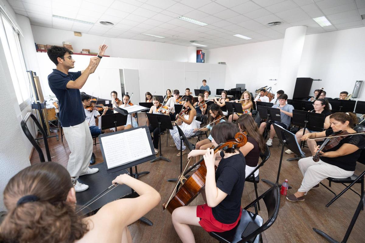 El director guía a los jóvenes músicos durante el ensayo.
