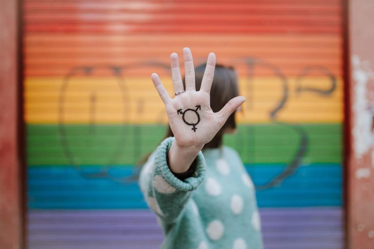 Una mujer frente a la bandera del Orgullo Gay.