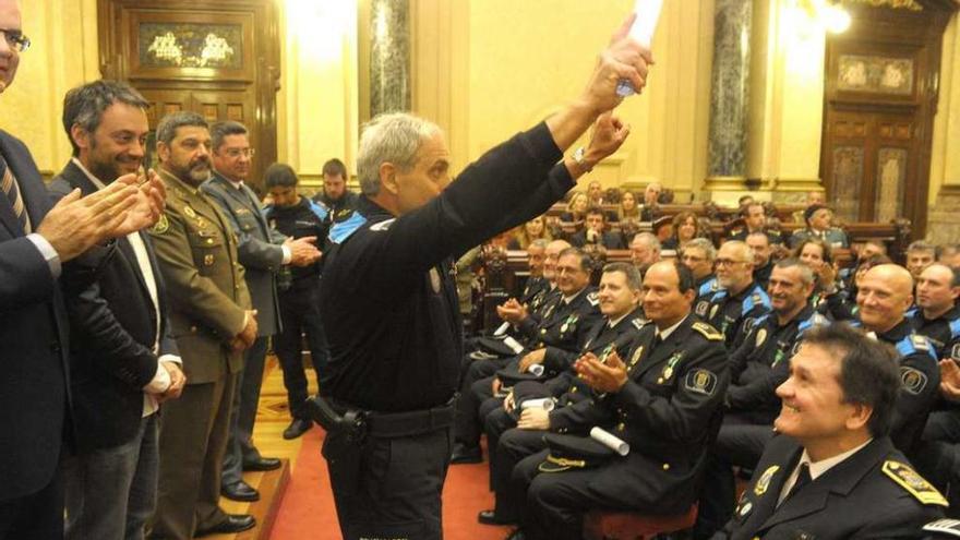 Un agente del 092 enseña una medalla a sus compañeros en el salón de plenos del Concello.