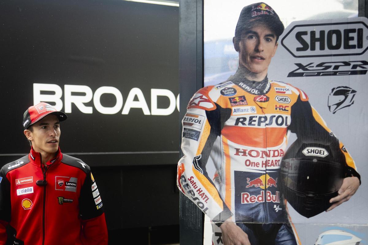 Marc Márquez pasa, hoy, en Assen, delante de un cartel en el que aún va vestido de Honda Repsol.