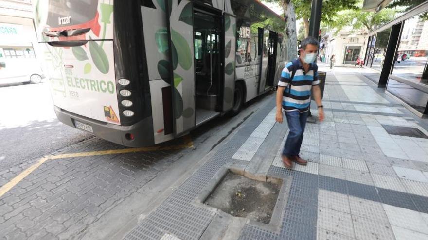 Un usuario de autobús esquiva un alcorque vacío en la calle Hernán Cortés.  | ÁNGEL DE CASTRO