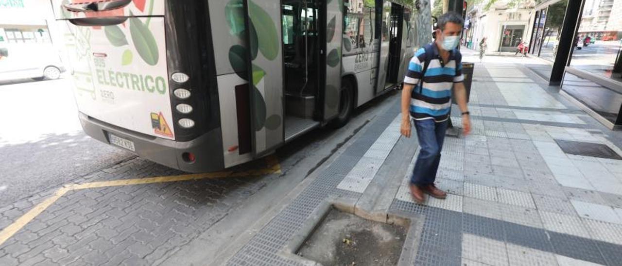 Un usuario de autobús esquiva un alcorque vacío en la calle Hernán Cortés.  | ÁNGEL DE CASTRO