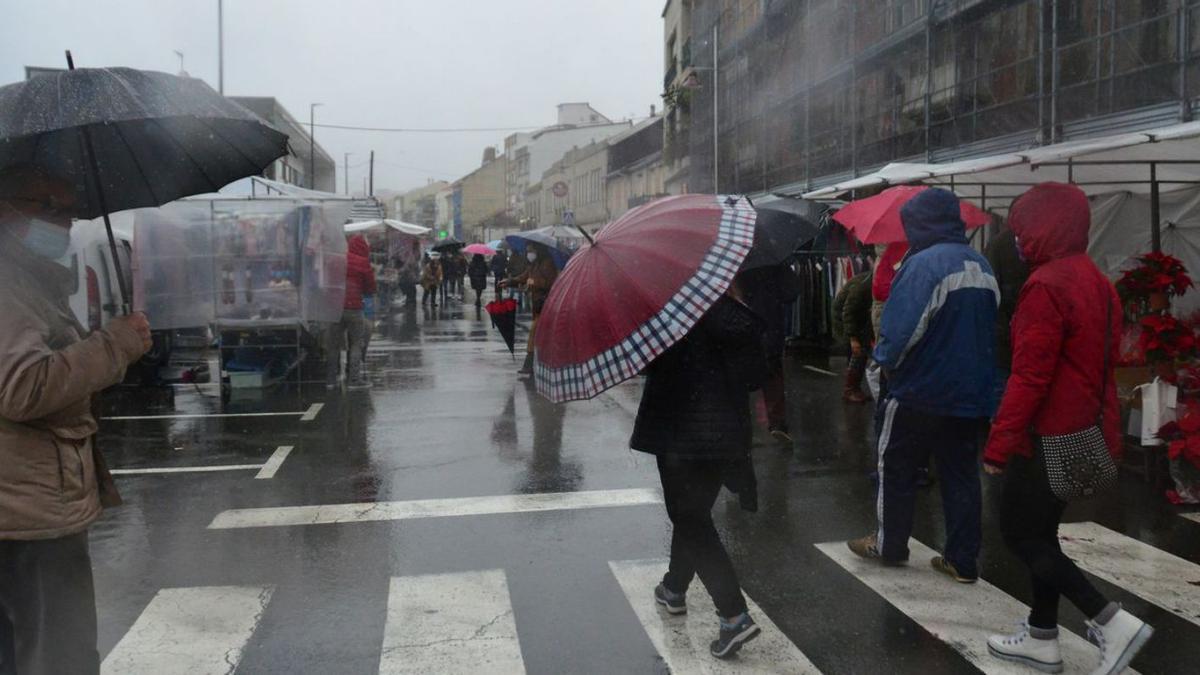 Un mercadillo pasado por agua y con muchos paraguas | GONZALO NÚÑEZ