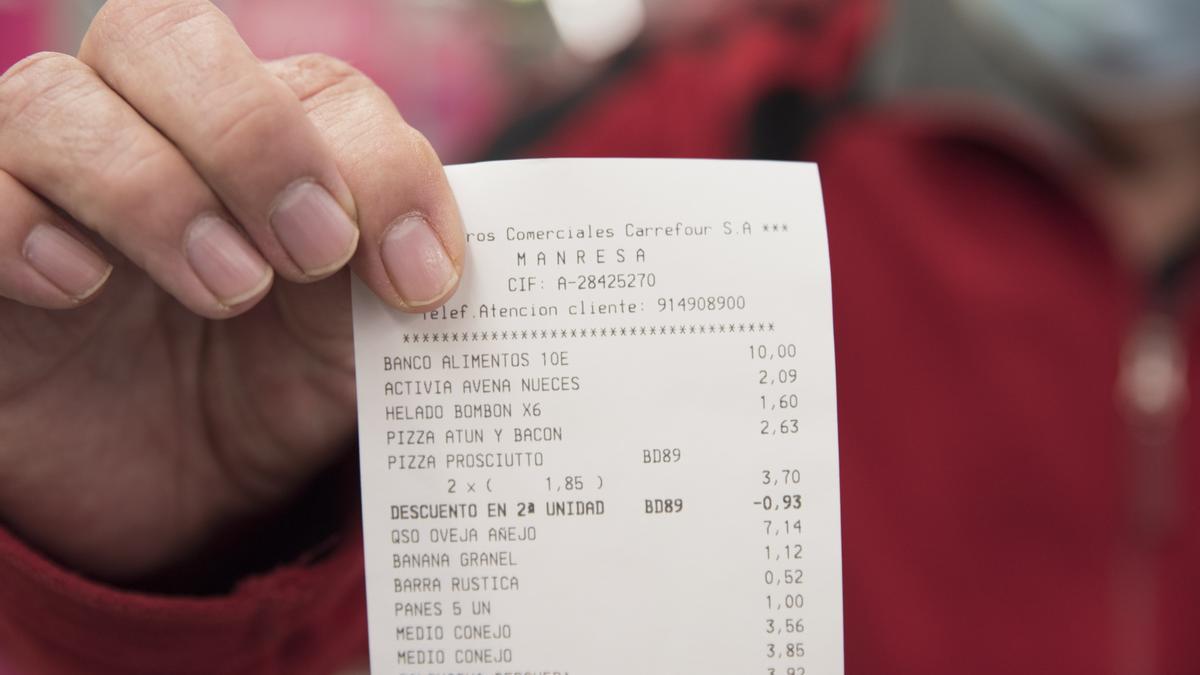 Un client del Carrefour de Manresa mostra una factura