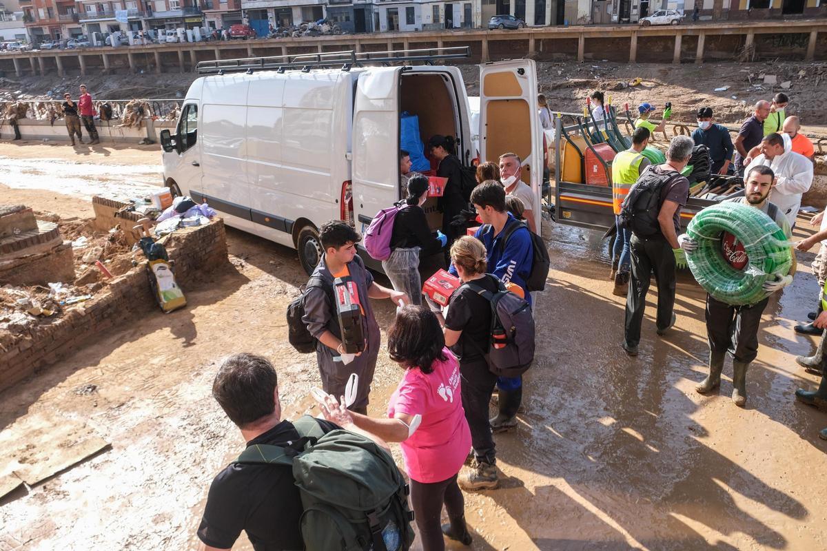 Voluntarios en Paiporta traen materiales para quitar el barro en los primeros días tras la dana