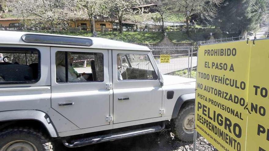 Un taxi traslada a vecinos por el paso provisional.