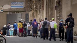 Colas para recoger comida en un comedor social del Raval de Barcelona, el pasado mayo.