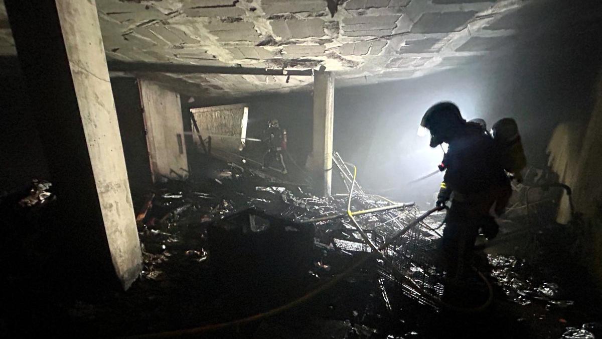 Un bomber treballa en un edifici ple de brossa.