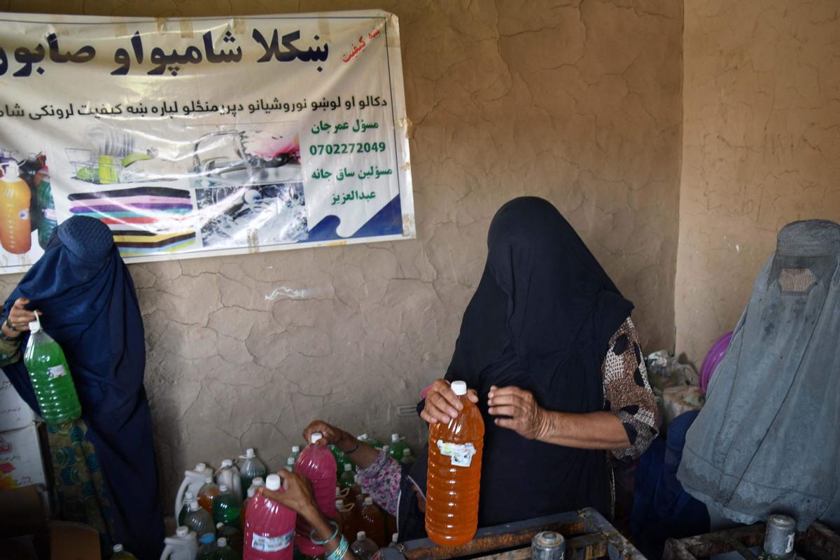 Afganas con burka trabajando en una fábrica de jabón y ropa en Kandahar