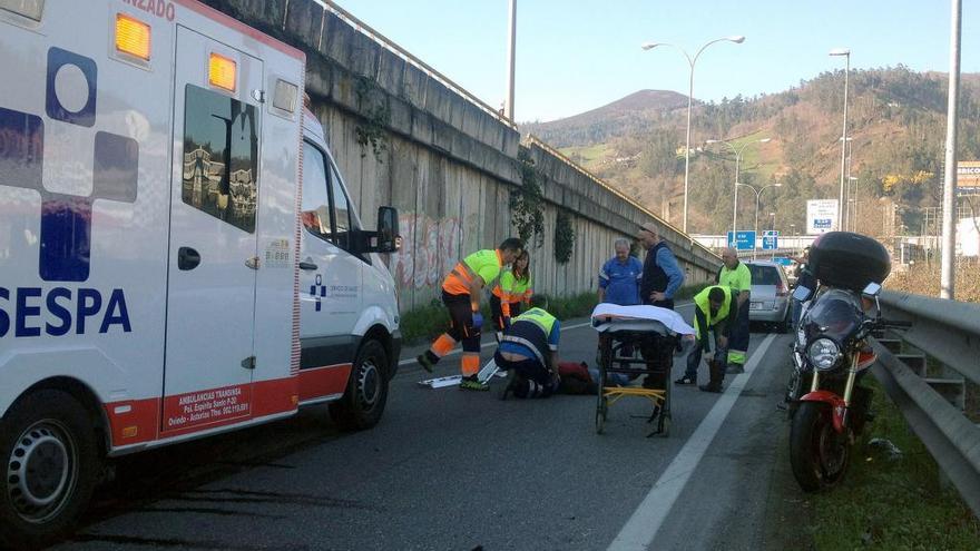 Personal sanitario asiste a un accidentado en moto.