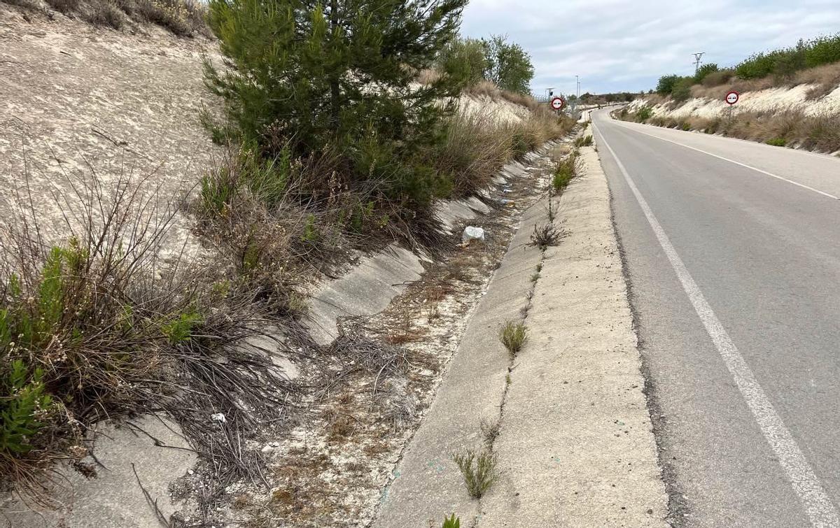 Calzada de la carretera con cuneta en el vial de acceso a la estación de ferrocarril de Vallada.