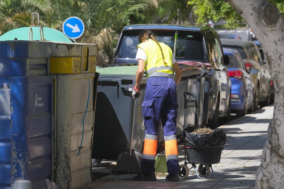 Una joven limpia las calles de la capital grancanaria.